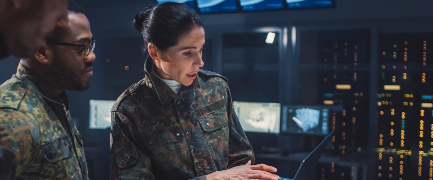 military personnel looking at a laptop